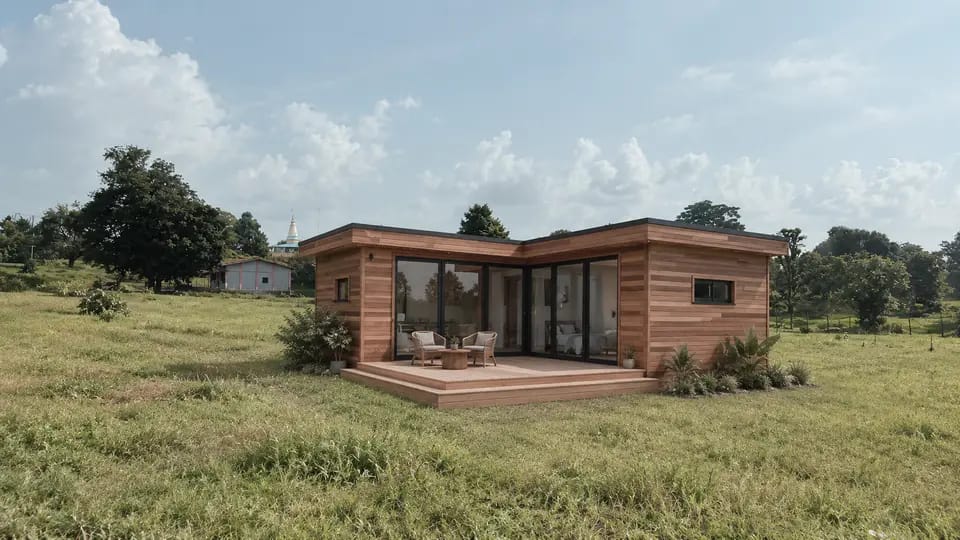 L-shaped wooden cabin standing in an open field