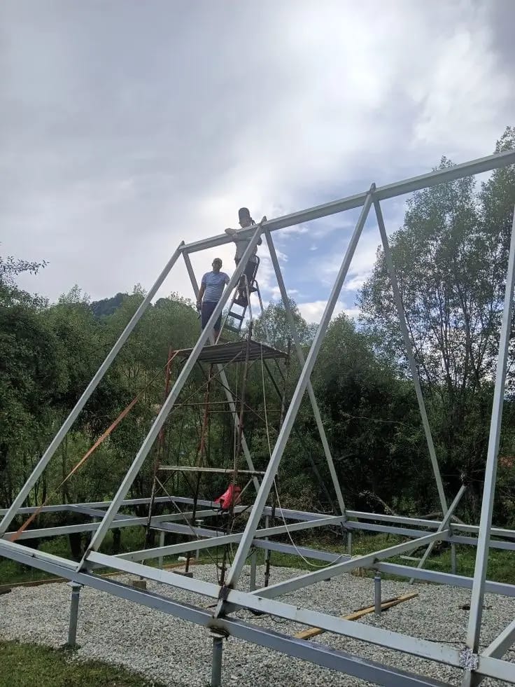 Workers installing a steel A-frame roof structure